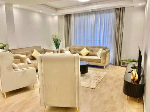 a living room with two couches and a tv at Modern Bole stay with city views, walk to airport in Addis Ababa