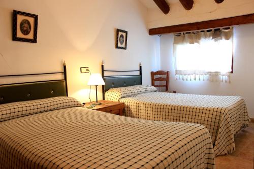 a hotel room with two beds and a window at La Muralla in Sabiote