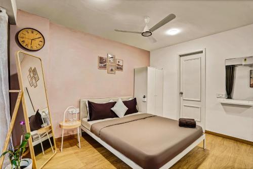 a bedroom with a bed and a clock on the wall at Orchid 001Airport view55 TVCoffee maker in Pune