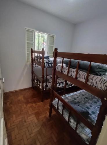 two bunk beds in a room with a window at Casa do Kazu in Águas da Prata