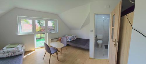 a small room with a bed and a table and chairs at Mazury Apartament/Dom z ogródkiem całoroczny przy jeziorze in Sędańsk