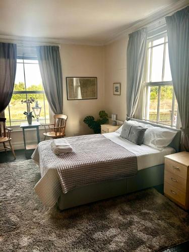 a bedroom with a large bed and a large window at The Fox and Hounds in Surbiton