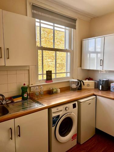 a kitchen with a washing machine and a sink at The Fox and Hounds in Surbiton