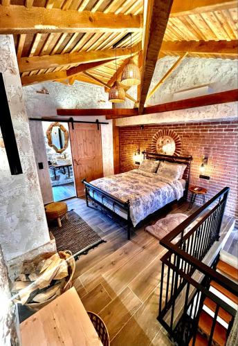 a bedroom with a bed and a brick wall at Olive Stone House in Alíartos
