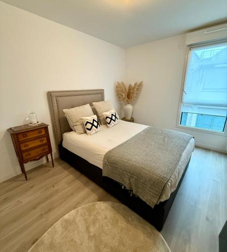 a bedroom with a large bed and a window at Malakoff - 3 pièces avec terrasse in Malakoff