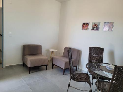 - une salle à manger avec des chaises, une table, une table et des chaises dans l'établissement Apto com dois quartos com cama e ar, à Juazeiro do Norte