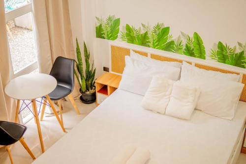 a bedroom with a white bed with two pillows at HayyaHayya Villas in Ocoy