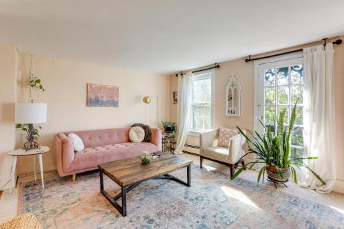 a living room with a pink couch and a table at Lambertville Retreat - Walk to Shopping and Dining! in Lambertville