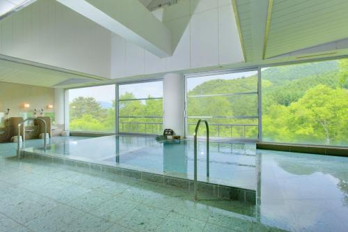 Cette grande chambre dispose d'une piscine avec de grandes fenêtres. dans l'établissement Minakami Kogen Hotel 200, à Minakami