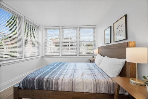 a bedroom with a bed and a desk and windows at Pittsburgh Shadyside 2A Bright and Stylish Private Bedroom with Shared Bathroom in Pittsburgh