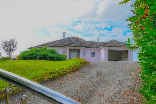 a white house with a hill in the background at Villa Lavanda in Križevci