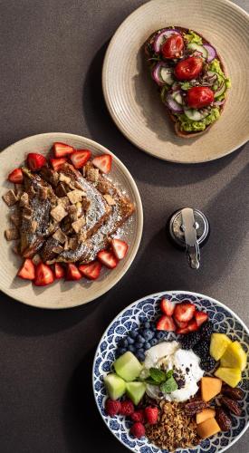 マートルビーチにあるvoco The Shelby - Myrtle Beach by IHGの食器2皿と果物1皿