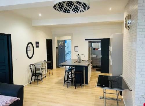a kitchen and living room with a table and chairs at Le bureau du Maire in Bourg-lès-Valence