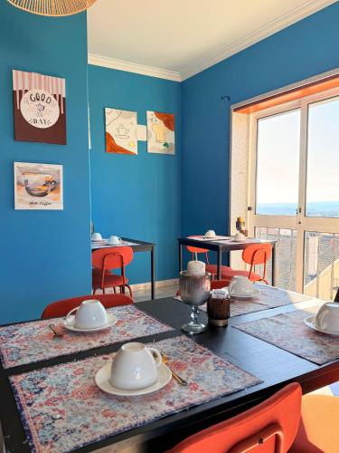 a dining room with blue walls and a table with chairs at Alojamento Local S. Bartolomeu in Trancoso