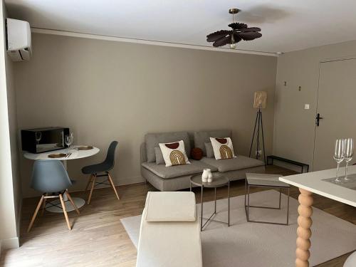 a living room with a couch and a table at Suite Romantique - Love Room Valence Amour et Bulles - Jacuzzi - Lit king size avec miroir XXL - Sofa Tantra - Drôme Ardèche in Bourg-lès-Valence