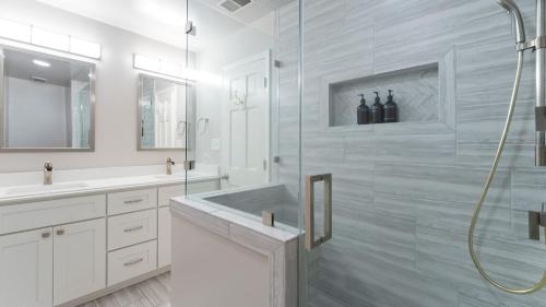 une salle de bain blanche avec une douche et un lavabo dans l'établissement Shades of Summer by AvantStay Gazebo Dock View, à Cornelius