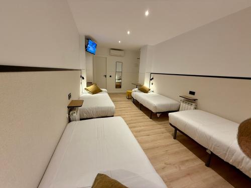 Cette chambre comprend 3 lits et une télévision. dans l'établissement Mucho Madrid, à Madrid