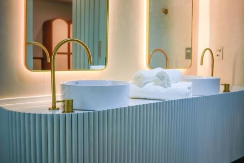a bathroom with two sinks and two mirrors at Farms Hotel in Coribe