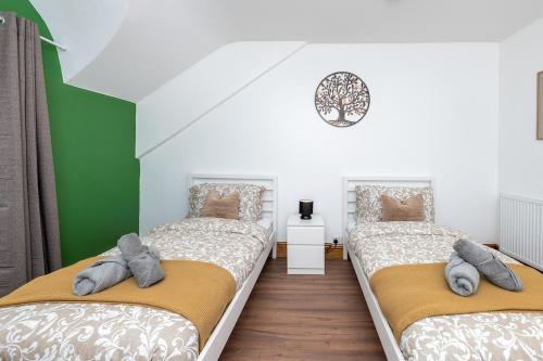 Dos camas en una habitación con verde y blanco. en Llangefni Town Centre 3 Bed Apt & Free Parking, en Llangefni