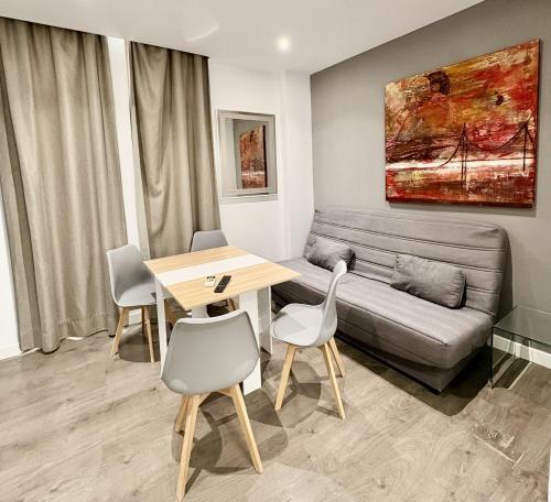 un soggiorno con un divano, un tavolo e delle sedie di Chillout 18 Granada centro a Granada