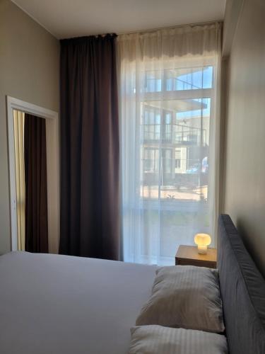 a bedroom with a bed and a large window at New apartment 5min to airport at Kokstad train station in Bergen