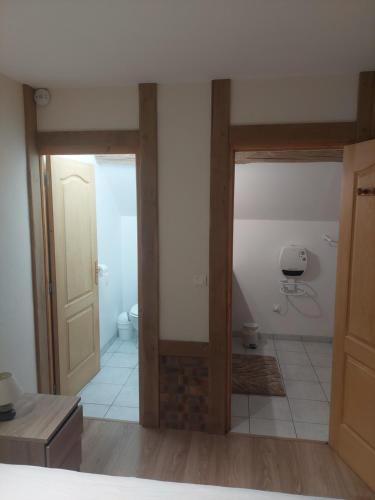 a room with a bathroom with a toilet and a door at Les puisayennes in Treigny