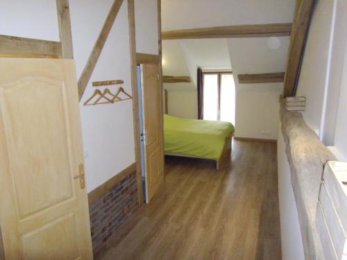 a small room with a bed and a door at Les puisayennes in Treigny
