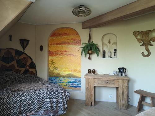 a bedroom with a bed and a wooden table at South African Room in Westbeemster