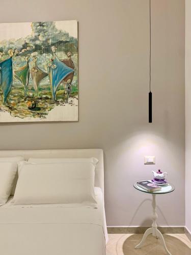 Santa Croce di MaglianoにあるVia Fico 20 - Holiday Homeのベッドルーム1室(ベッド1台、絵画のあるテーブル付)