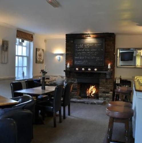 a restaurant with a fireplace and a table and chairs at Ferryboat Inn in Pangbourne