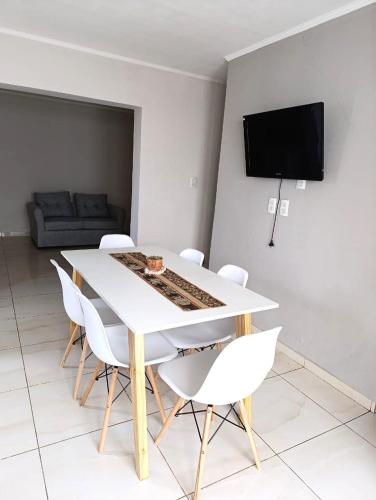 una sala da pranzo con un tavolo bianco e sedie bianche di CASA en Olavarría - Pueblo Nuevo a Olavarría