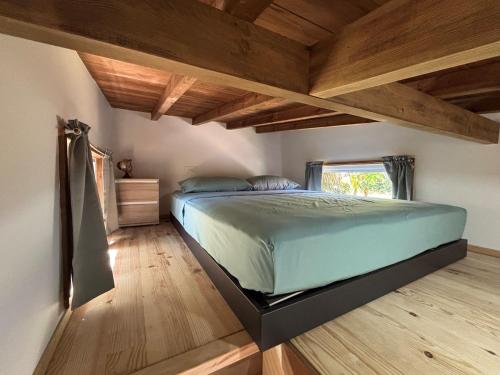 a bedroom with a bed in a room with wooden ceilings at Tiny Surf in Punaauia