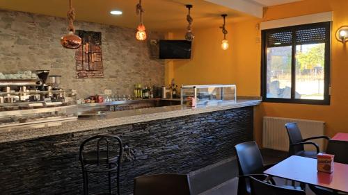 a bar in a restaurant with tables and chairs at Hostal Restaurante Las Cavenes Del Cabaco in El Cabaco