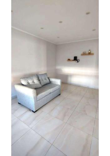 un soggiorno con un divano su un pavimento piastrellato di CASA en Olavarría - Pueblo Nuevo a Olavarría