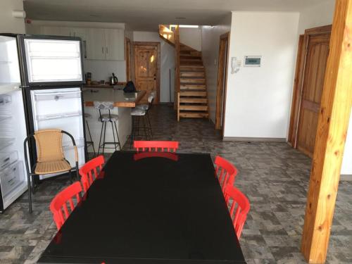 a dining room with a black table and red chairs at Gran casa con preciosa vista in Huasco