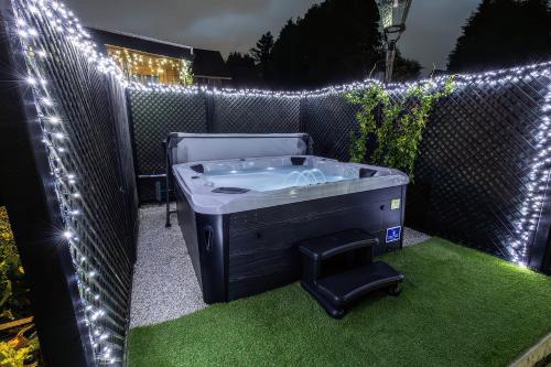 Ein Whirlpool steht mit Lichtern auf einer Rasenfläche. in der Unterkunft Rose Cottage in Nottingham