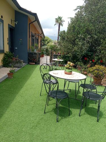 a patio with a table and chairs on the grass at Ai 4 gatti in Mascalucia