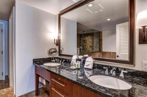 une salle de bain avec deux lavabos et un grand miroir dans l'établissement Honua Kai 3 Free Rental Cars KBM Resorts Ocean Front 3 Units 6 Bedrooms HK ML-1119, à Kaanapali Airport