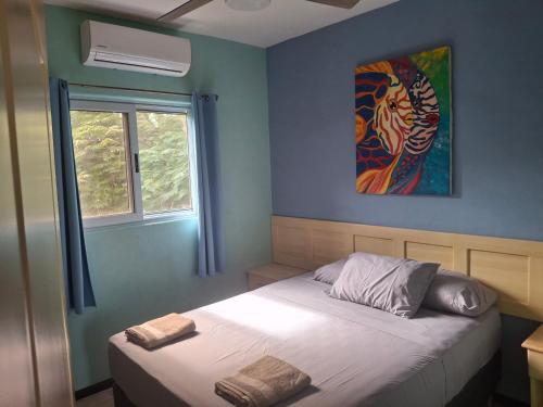 a bedroom with a bed and a painting on the wall at Casa palmera in San Juan del Sur