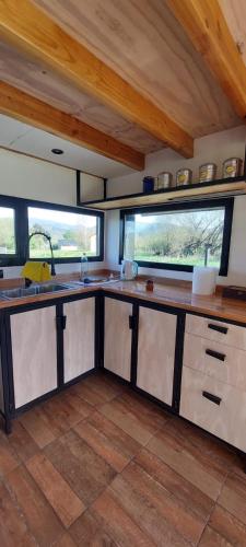 - une cuisine avec des comptoirs en bois et des fenêtres dans l'établissement Cabaña Linna, à El Hoyo