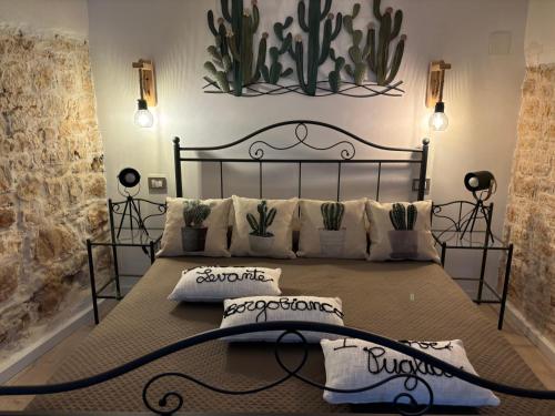 a bedroom with a large bed with plants on the wall at Dimore Levante Borgobianco in Turi