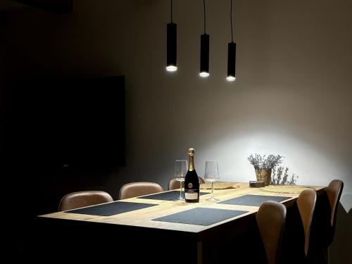 a dining room table with a bottle of wine and chairs at Central House - Modern Apartment in Zărneşti