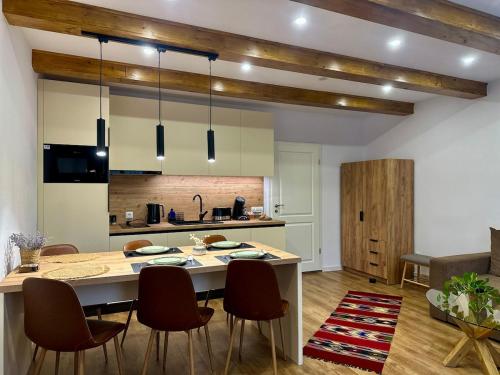 a kitchen with a table and chairs in a room at Central House - Modern Apartment in Zărneşti