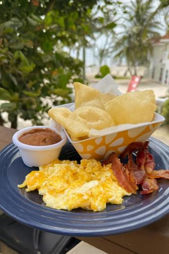 a plate of breakfast food with eggs and chips and dips at Marbucks Bed & Breakfast in San Pedro