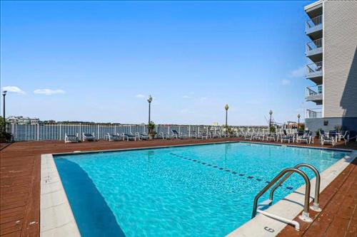 a large swimming pool with chairs and a building at Assateague House 511 in Ocean City