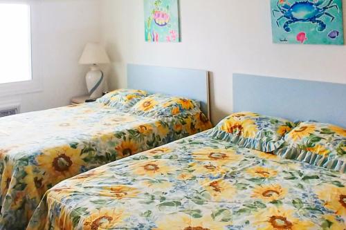 two beds sitting next to each other in a bedroom at Assateague House 511 in Ocean City