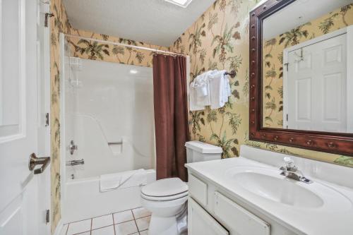 a bathroom with a toilet and a sink and a mirror at Tidewater 1911 in The Old Home Place