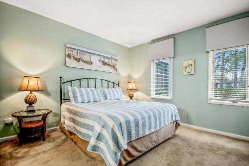 a bedroom with a bed and two windows at Tidewater 1911 in The Old Home Place