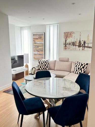 a living room with a couch and a table and chairs at Spacious Urban Gem Apartment with parking in Bracknell
