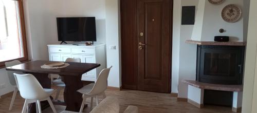 a dining room with a table and chairs and a television at Villa MB in Lenna